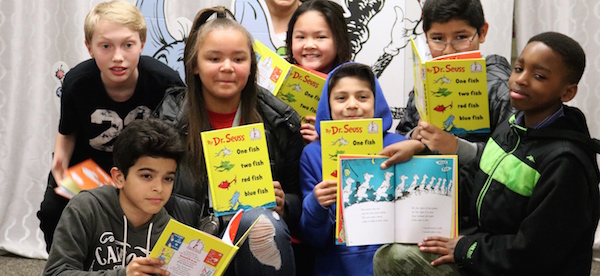 Group of students holding up books