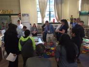 Participants gather around mock-up designs for new school
