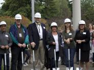 Board members and the superintendent gather with students for the groundbreaking