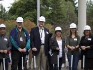 Board members and the superintendent gather with students for the groundbreaking