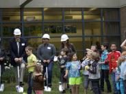 Board members and the superintendent gather with students for the groundbreaking