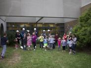 Board members and the superintendent gather with students for the groundbreaking