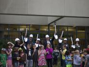 Board members and the superintendent gather with students for the groundbreaking