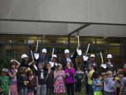 Board members and the superintendent gather with students for the groundbreaking