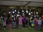 Board members and the superintendent gather with students for the groundbreaking