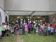 Board members and the superintendent gather with students for the groundbreaking