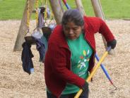 Volunteer clearing away dirt from playground