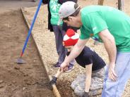 Volunteers clear dirt on the playground