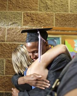 Reynolds Learning Academy Graduate hugs guest after ceremony