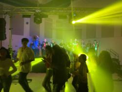 Students dancing as band plays in the distance