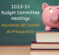 Pink piggy bank on stack of three books with the text "2023-24 Budget Committee Meetings" on a chalkboard 